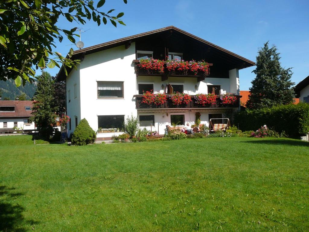 ein weißes Haus mit Blumenkästen an den Fenstern in der Unterkunft Ferienwohnungen Kathrein in Reutte