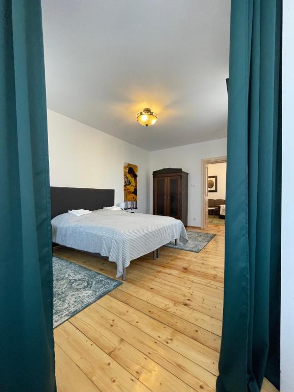 Apartament w starej kamienicy w Reszlu في ريشيل: غرفة نوم بسرير وارضية خشبية