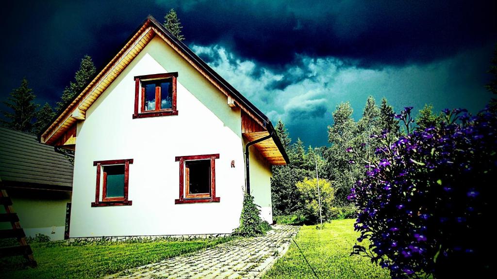 a white house with two windows on the side of it at Chatka Bukowina in Wetlina