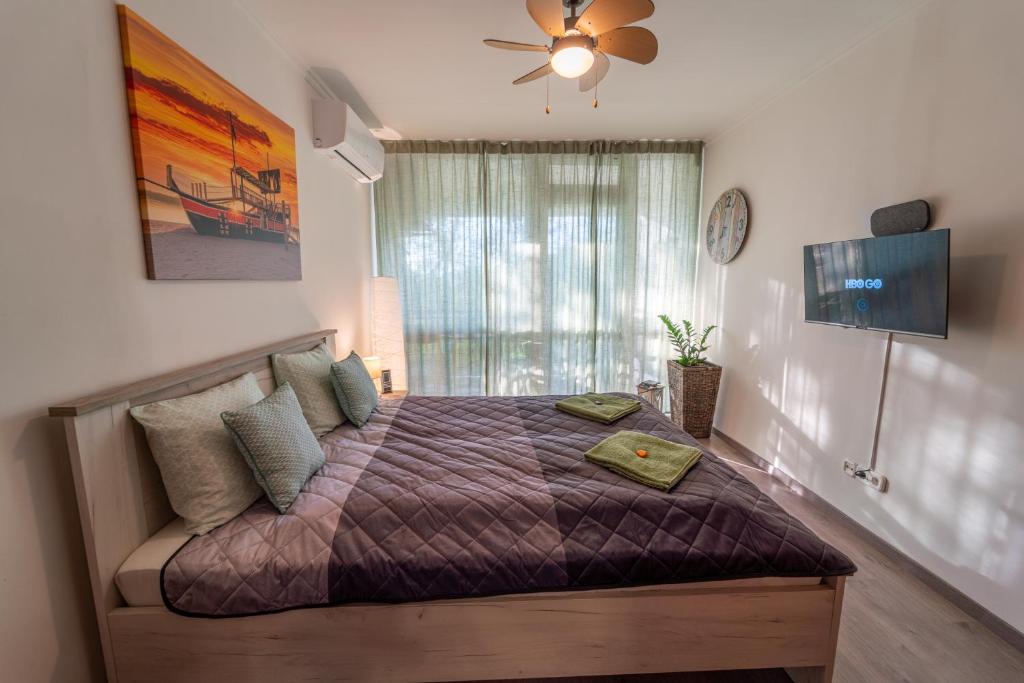 a bedroom with a bed and a ceiling fan at VIP Apartman Balatonföldvár in Balatonföldvár