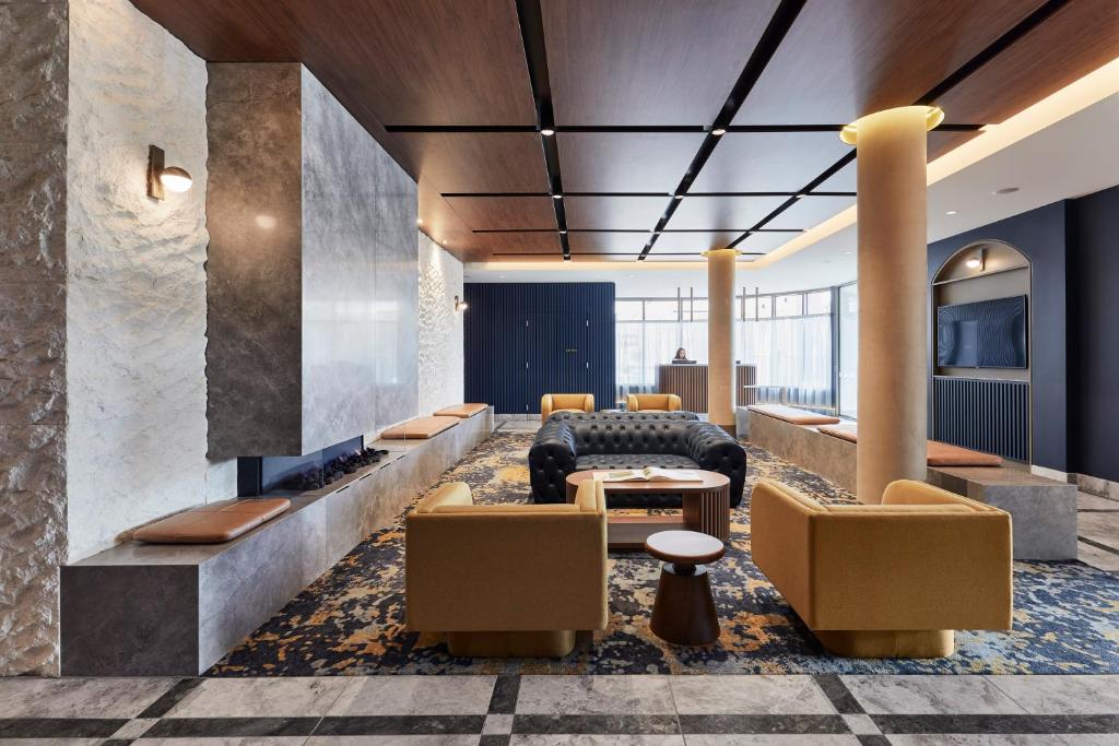a lobby with couches and a table and chairs at Rydges Ringwood in Ringwood