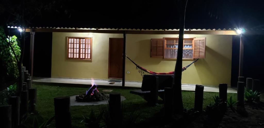 a house with a hammock in front of it at night at Cabana da Montanha - Sítio Pasangas in Santo Antônio do Pinhal