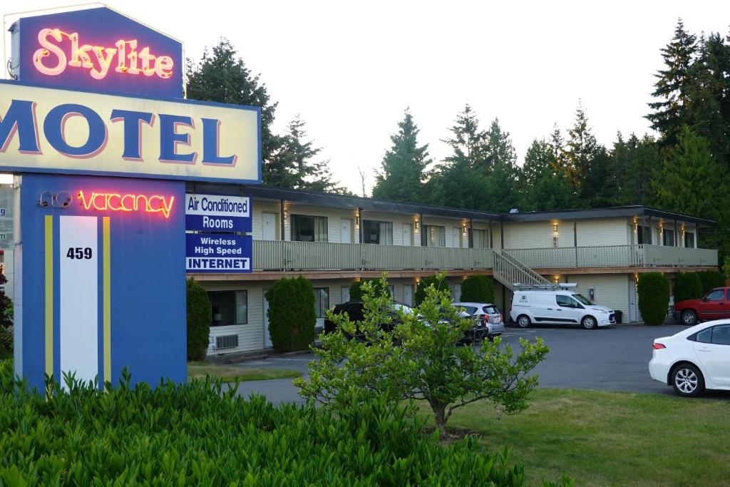 una señal de motel frente a un estacionamiento en Skylite Motel, en Parksville
