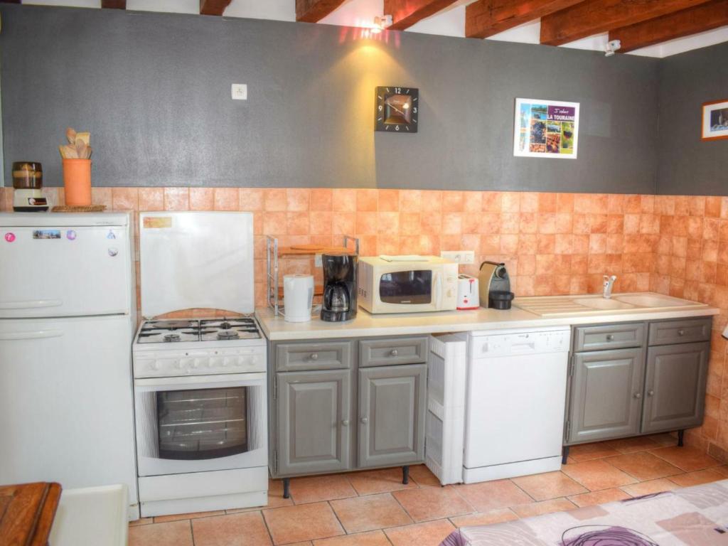 a kitchen with a stove and a microwave at Gîte Montrésor, 4 pièces, 7 personnes - FR-1-381-72 in Montrésor