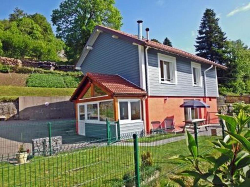 une petite maison avec une clôture devant elle dans l'établissement Gîte Saulxures-sur-Moselotte, 3 pièces, 5 personnes - FR-1-589-339, à Saulxures-sur-Moselotte