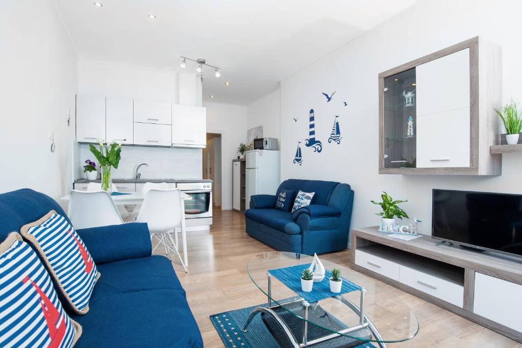 a living room with a blue couch and a kitchen at Oasis of Peace and Relaxation II. in Ičići