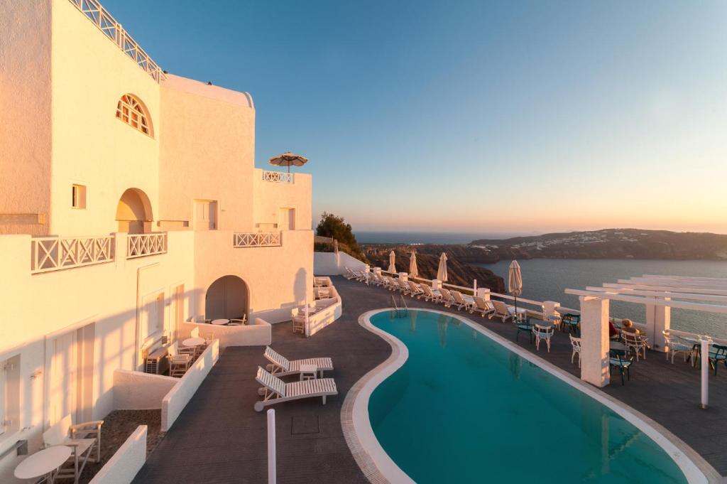 un hotel con piscina sul lato di un edificio di Artemis Suites a Megalochori