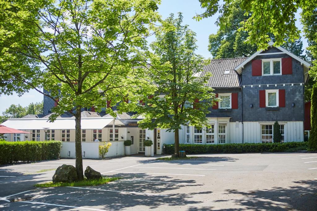 ein großes Haus mit einem Baum davor in der Unterkunft Parkhaus Hügel in Essen