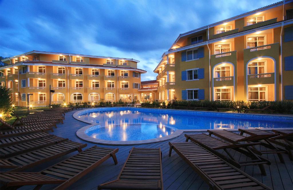 a hotel with a swimming pool in front of two buildings at Blue Orange Beach Resort in Sozopol
