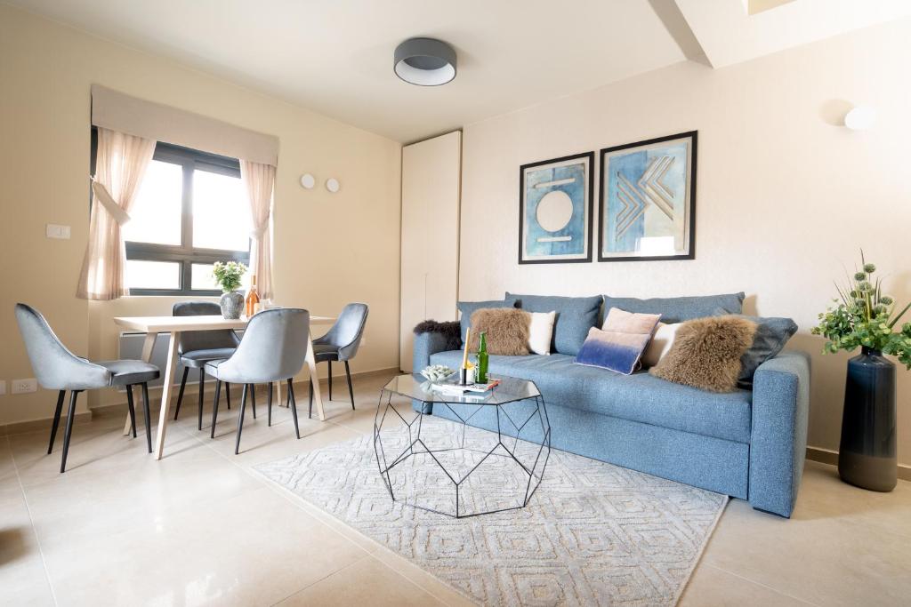 sala de estar con sofá azul y mesa en Sweet Inn - Chic Keren Hayesod, en Jerusalén