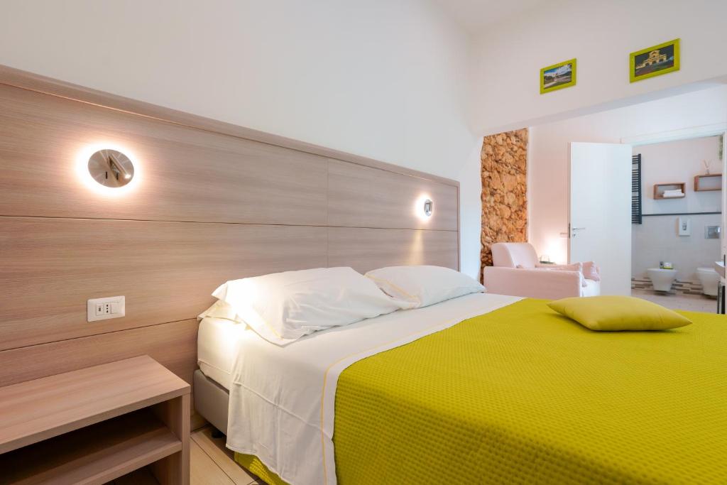 1 dormitorio con 1 cama grande y pared de madera en Bardilio Luxury Rooms en Cagliari