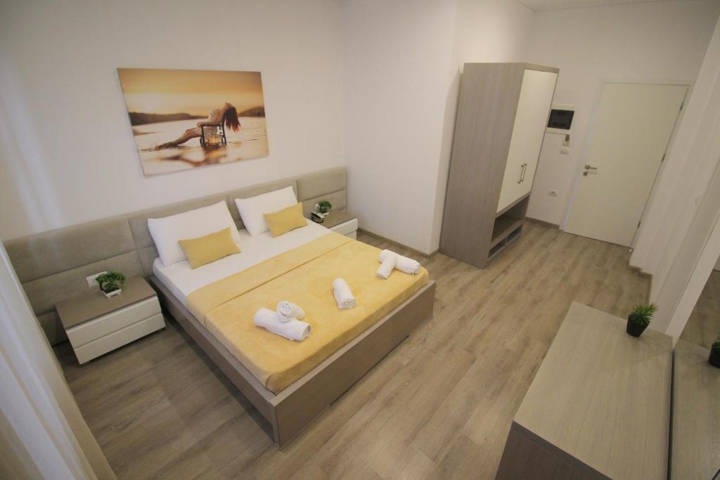 a small bedroom with a bed with towels on it at Zero Zero Apartments Sarande in Sarandë