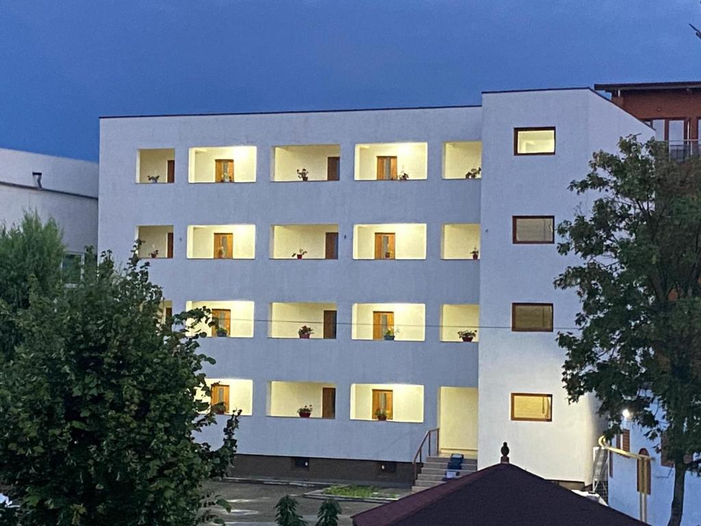 um edifício de apartamentos branco com pessoas sentadas nas varandas em Vila II Poieniţa em Costinesti