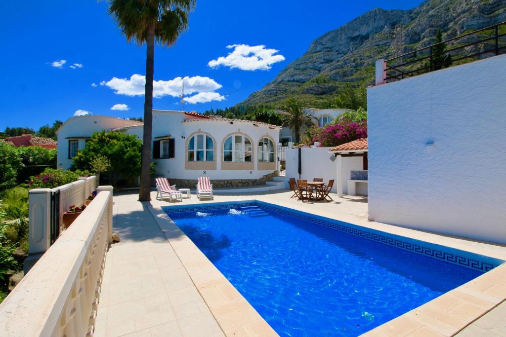 eine Villa mit einem Pool und einem Haus in der Unterkunft Don Quijote LA in Denia