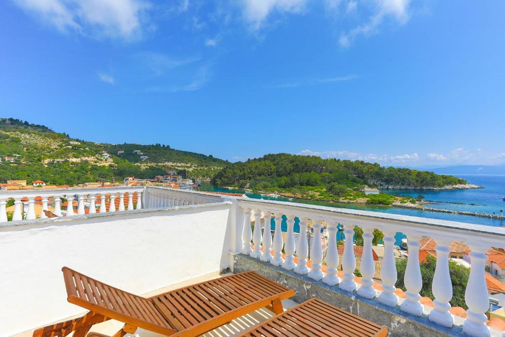 een balkon met een bank en uitzicht op de oceaan bij Vista Mare Faros in Gaios