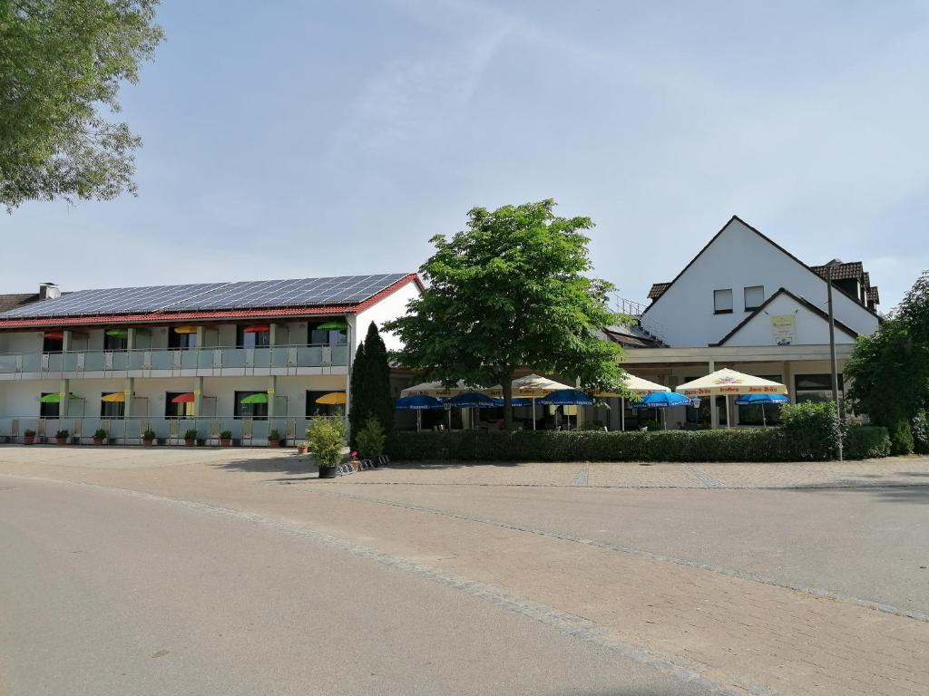 ein großes Gebäude mit Sonnenschirmen davor in der Unterkunft Gasthaus Pension Rezatgrund in Windsbach