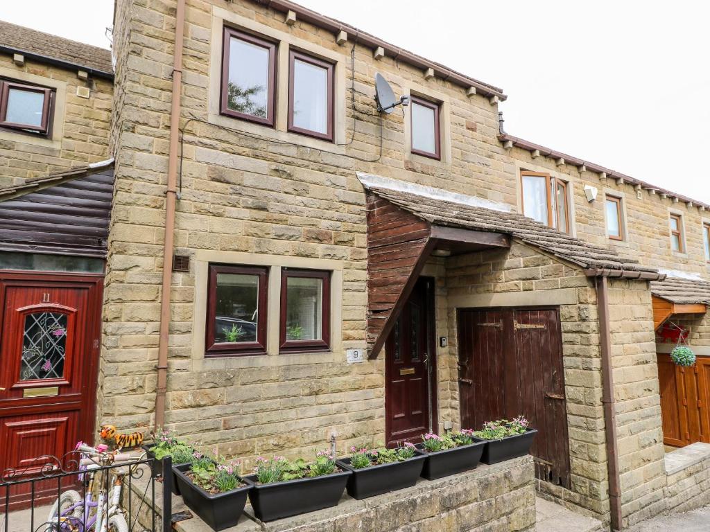 a brick house with plants in front of it at Duck Egg Cottage in Keighley