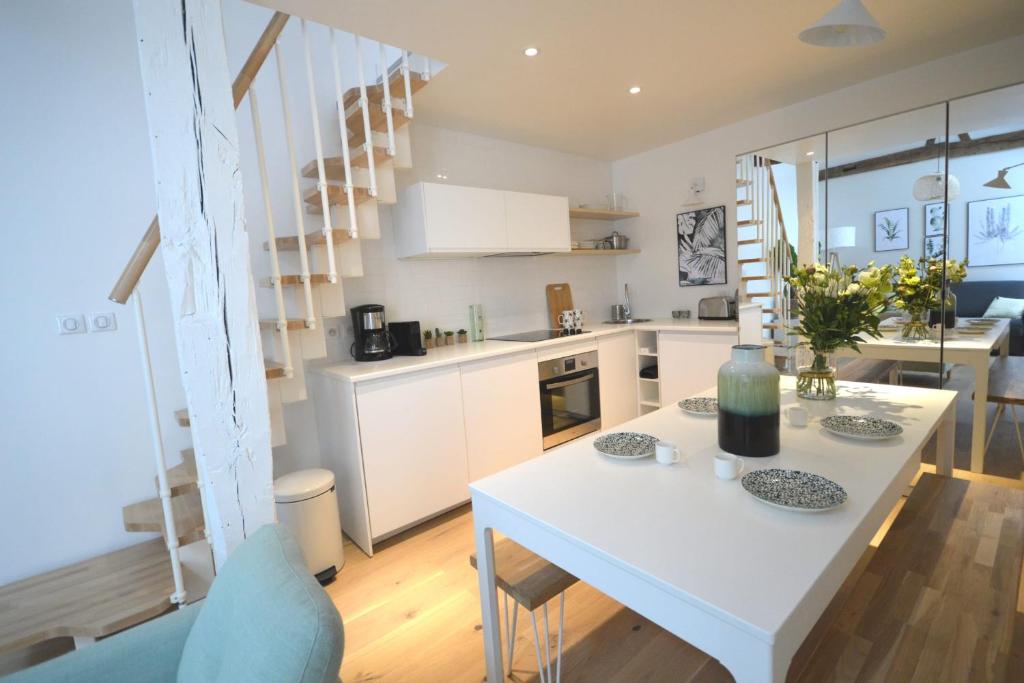eine Küche und ein Wohnzimmer mit einem weißen Tisch und Stühlen in der Unterkunft Sweet Jardin des plantes in Paris