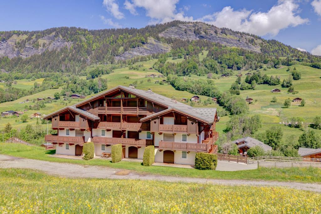 uma casa numa colina com uma montanha em L'Ecureuil em Flumet