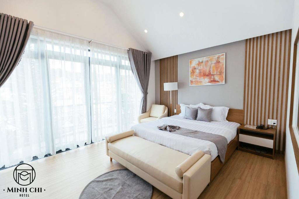 a bedroom with a large bed and a large window at Minh Chi Hotel in Da Lat