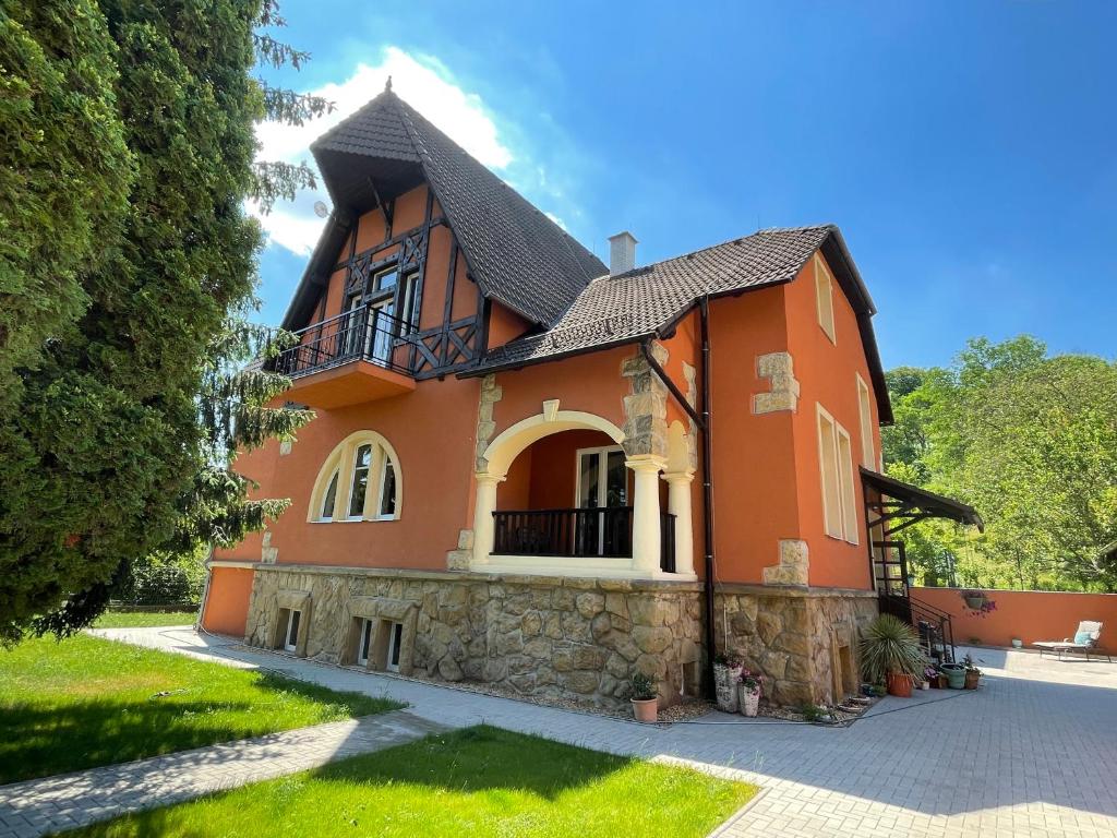 une maison orange avec un toit noir dans l'établissement Penzion Villa Amélie, à Mladá Boleslav