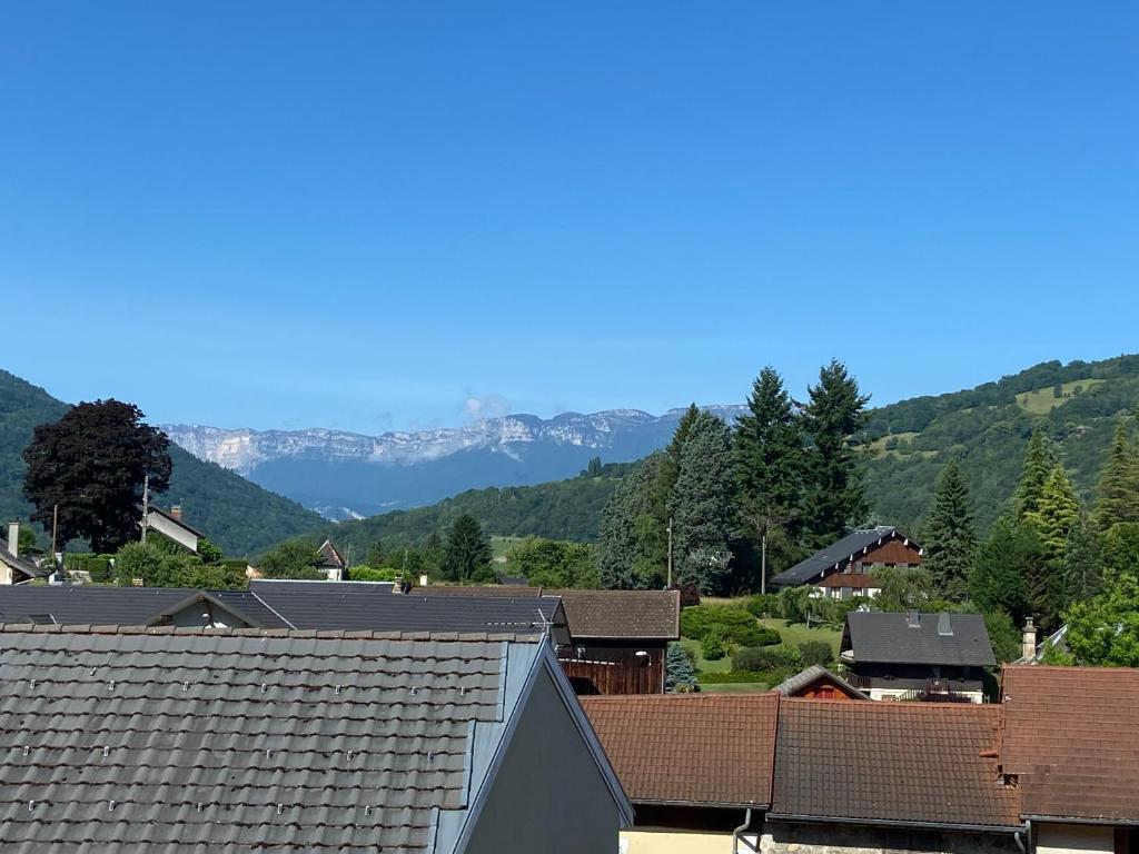 a town with roofs and mountains in the background at Appartement Le Rochettois - VALGELON LA ROCHETTE - 25 mn station de ski Collet d'Allevard in La Rochette