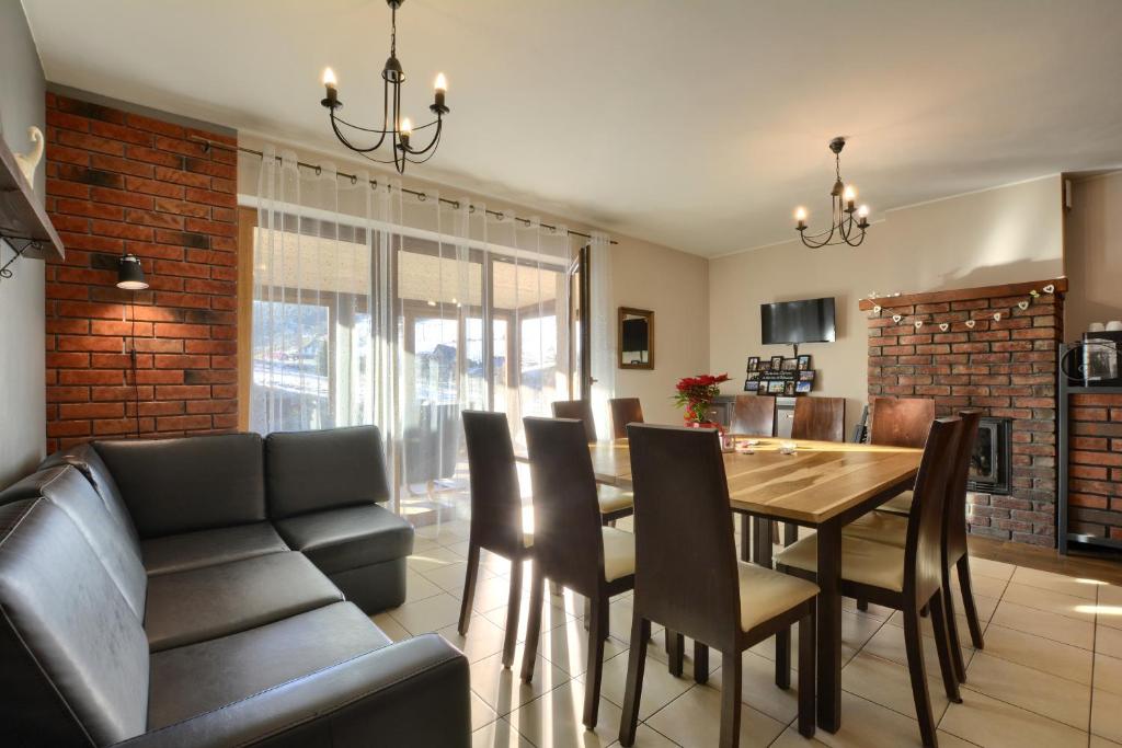 a dining room with a table and chairs and a couch at Domek Zieleniec in Duszniki Zdrój