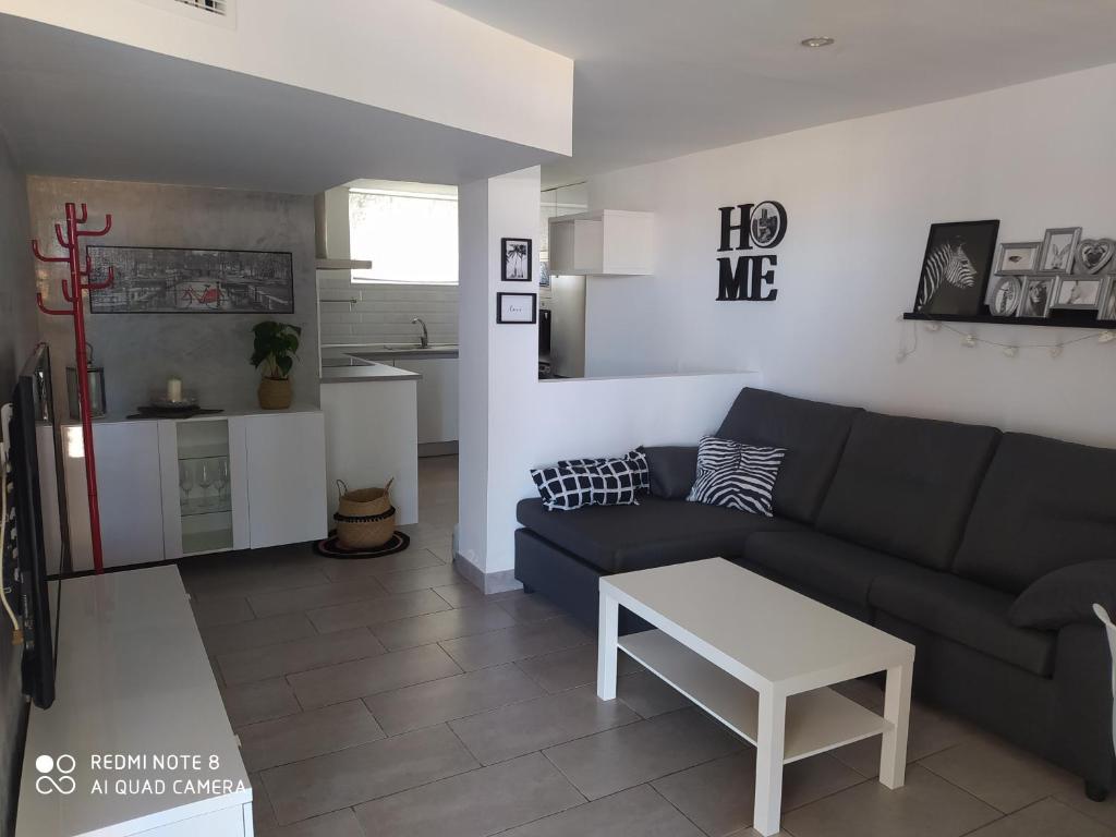 un salon avec un canapé et une table dans l'établissement Apartamento en primera línea de playa, à Sanlúcar de Barrameda