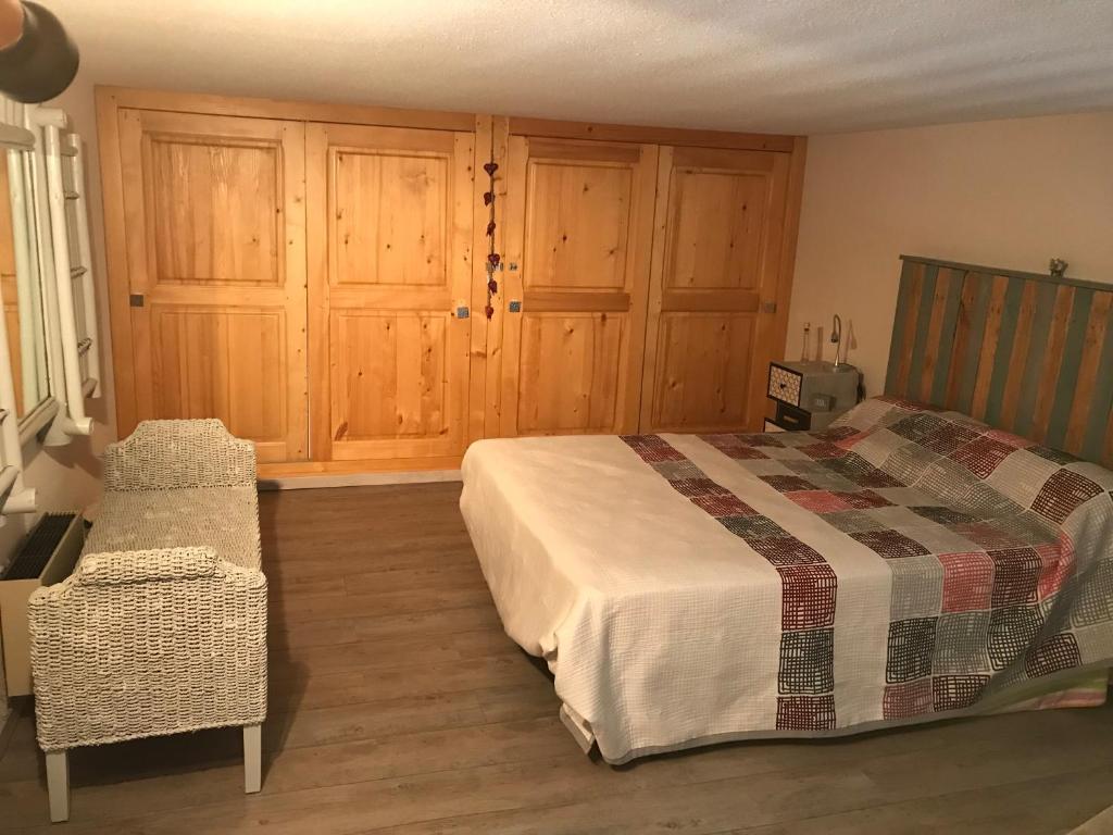 a bedroom with a bed and wooden cabinets at Appartement Hauteur Barcelonnette Vue Exceptionnelle in Barcelonnette