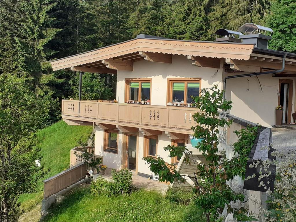a house on a hill with a balcony at Ferienwohnung Waldglück in Reith bei Kitzbühel