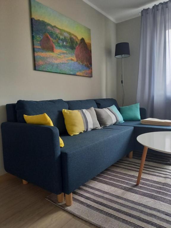 a blue couch with colorful pillows in a living room at Apartament 26 in Drawsko Pomorskie