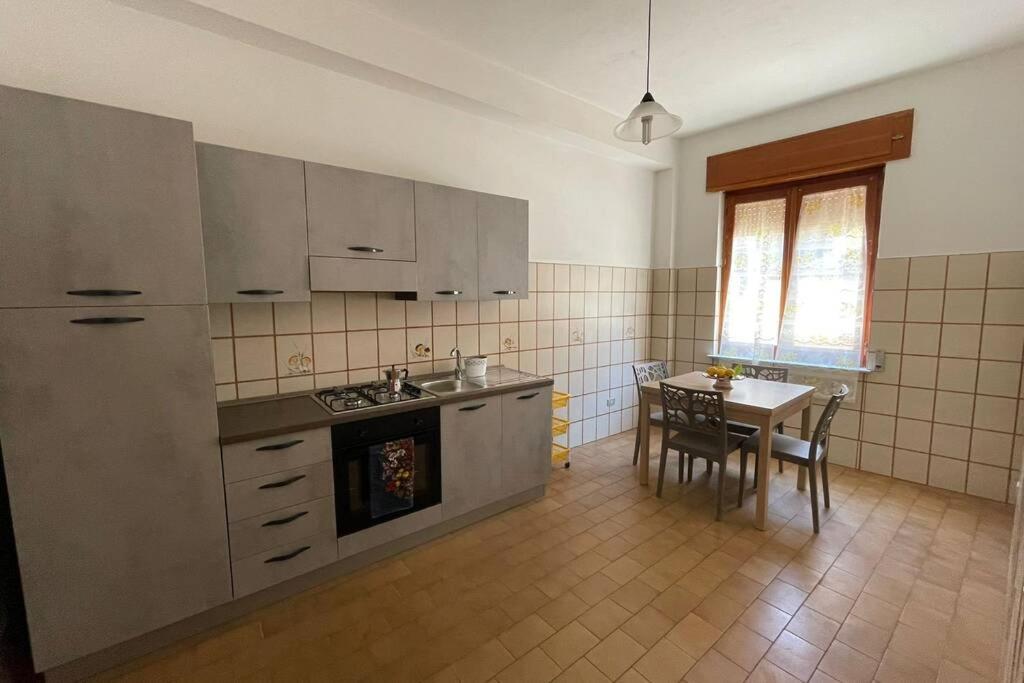 a kitchen with a table and a dining room at Amplio e luminoso appartamento nel cuore di Le Castella in Le Castella