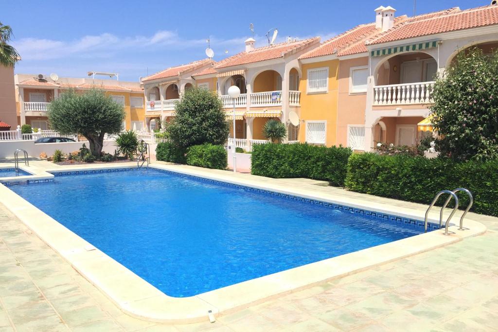 a swimming pool in front of a house at Pancho Apartment Doña Pepa - C. Quesada in Rojales