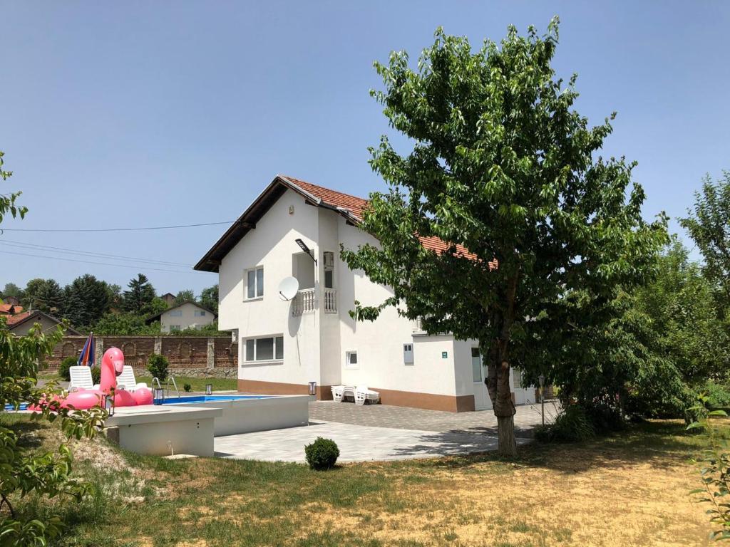 een huis met een zwembad en een boom bij House Skoko in Sarajevo
