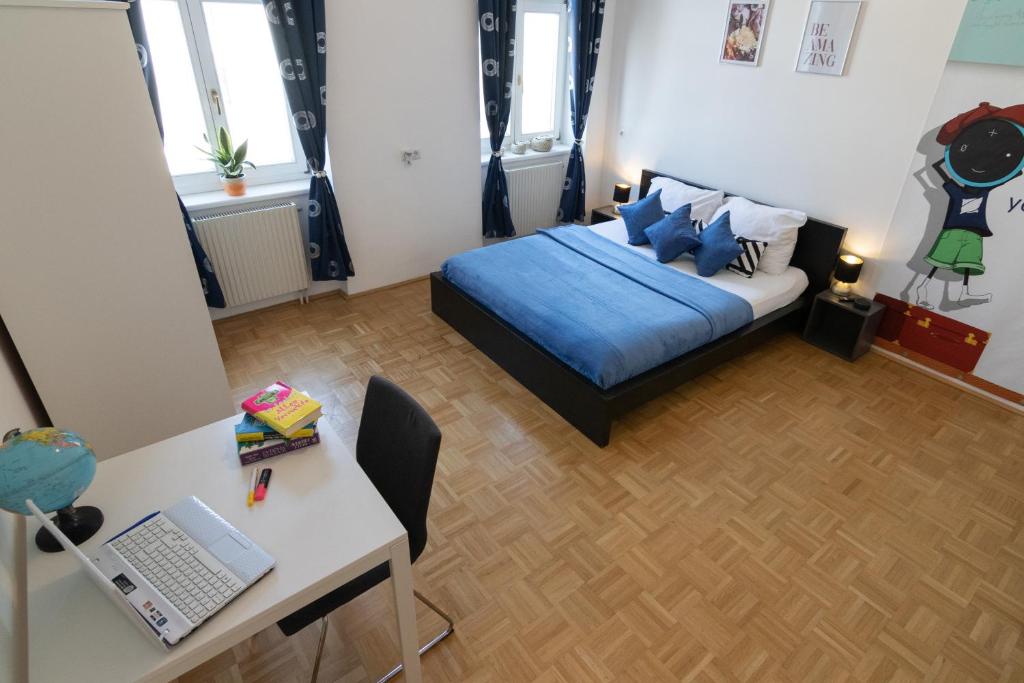 - une chambre avec un lit et un bureau avec un ordinateur portable dans l'établissement Yeshello Apartment near Central Station, à Vienne