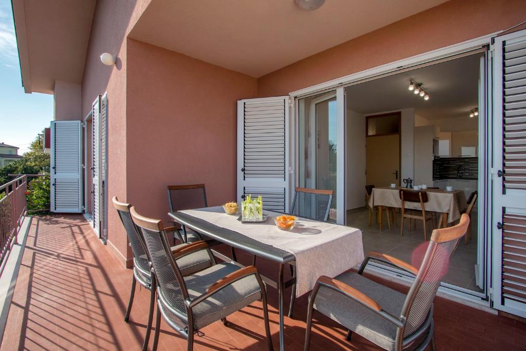 a dining room with a table and chairs on a balcony at Apartment Rubina with secure parking in Medulin
