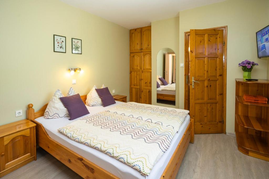 a bedroom with a large bed and a door at Cecey Apartman in Eger