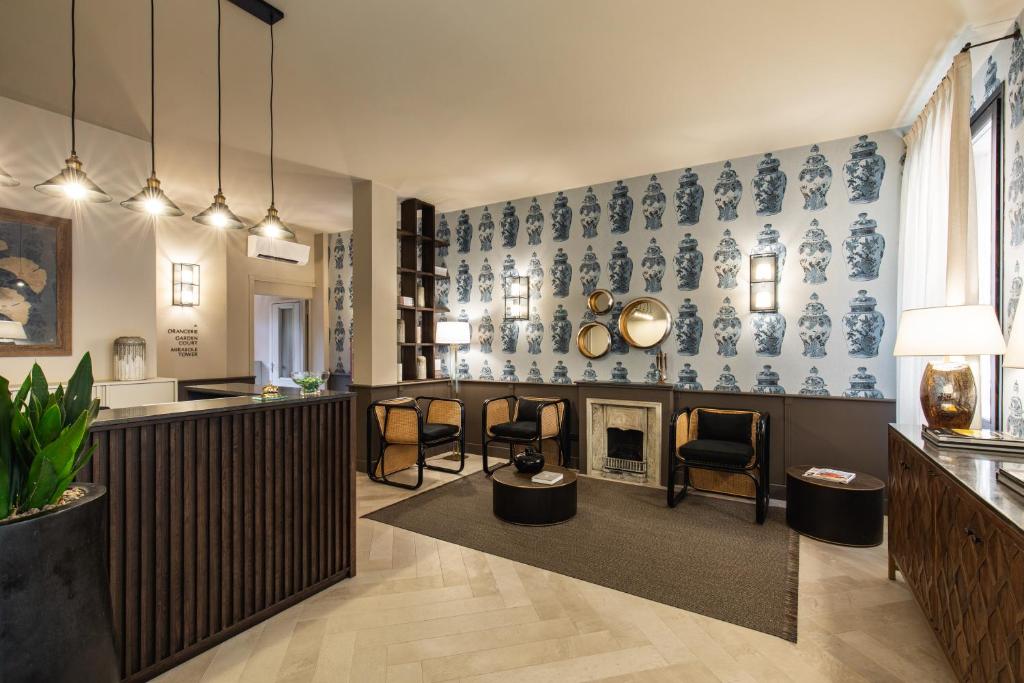 a living room with a fireplace and blue and white wallpaper at Hotel Porta San Mamolo in Bologna