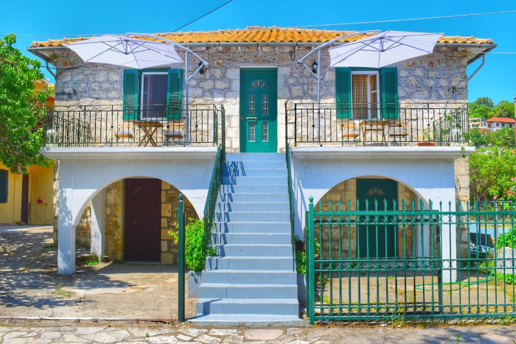 een huis met een groene deur en een trap bij Karydia Apartments in Lazaráta