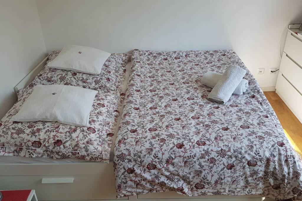 uma cama com uma colcha floral e almofadas em Mini apartment in fairy-tale city! em Heidelberg