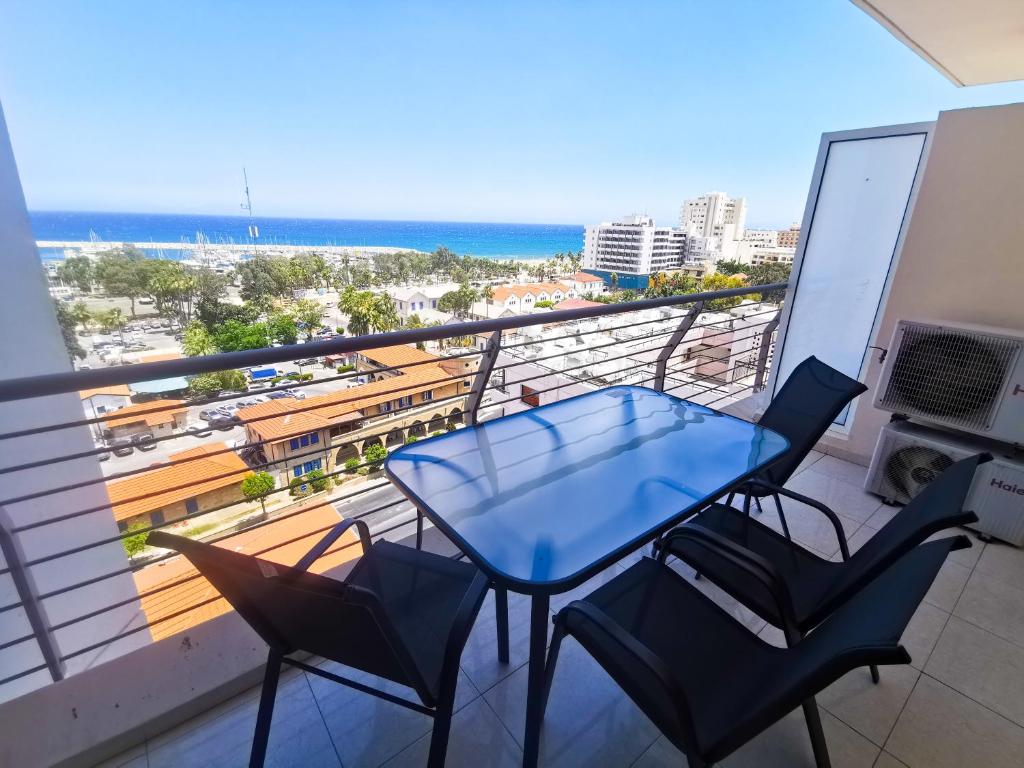 a blue table and chairs on a balcony with the beach at Paradise Palms Seaview Apartment in Larnaka