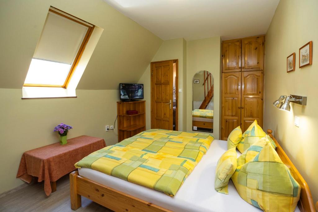a bedroom with a bed with a yellow and green comforter at Cecey Apartman in Eger