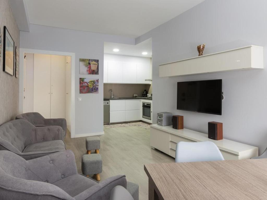- un salon avec deux chaises et une télévision à écran plat dans l'établissement Click&Flat Xoriguer, à Barcelone