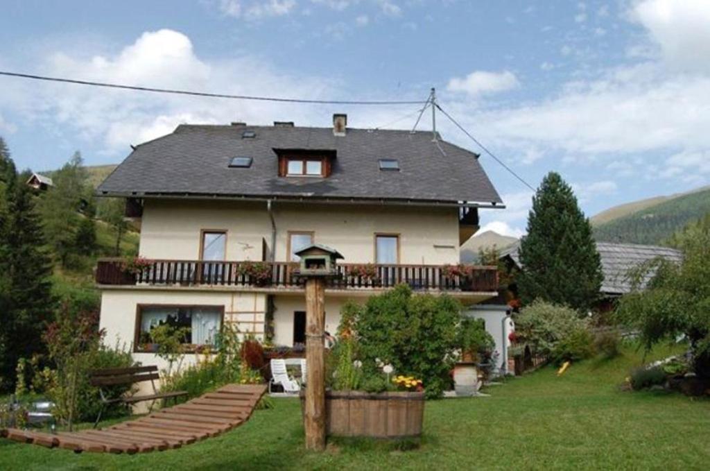 uma casa grande com uma varanda no topo de um quintal em Zur alten Schmiede em Bad Kleinkirchheim