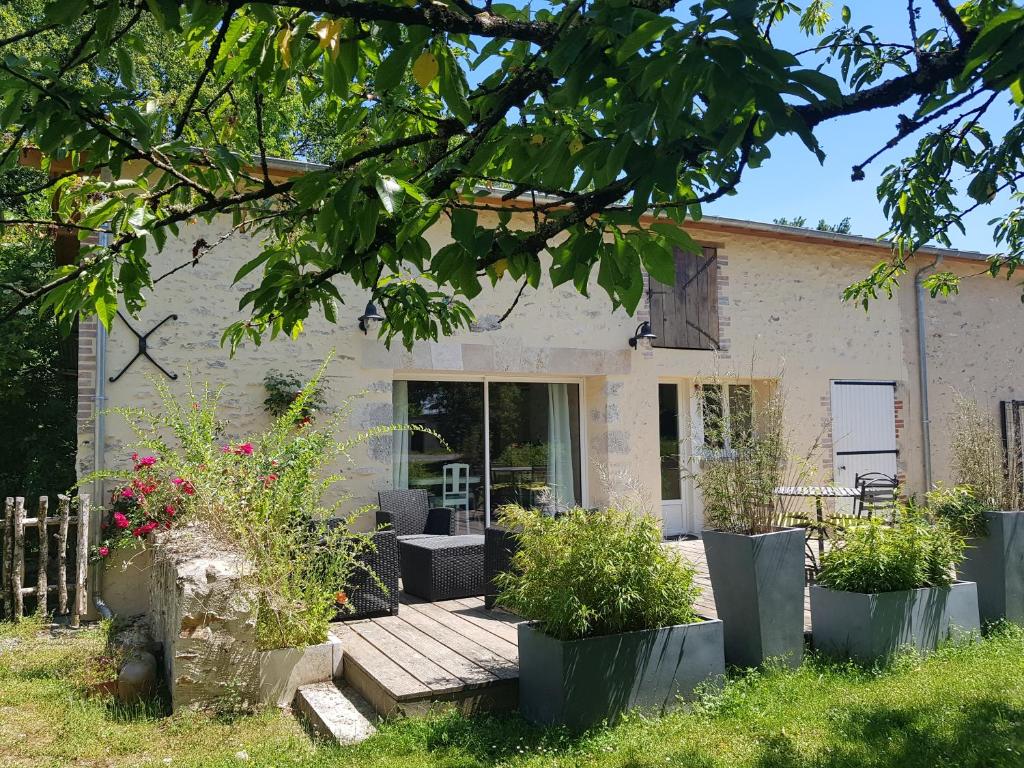 ein Haus mit einer hölzernen Veranda mit Pflanzen davor in der Unterkunft 21 Les Boissières in Saint-Branchs