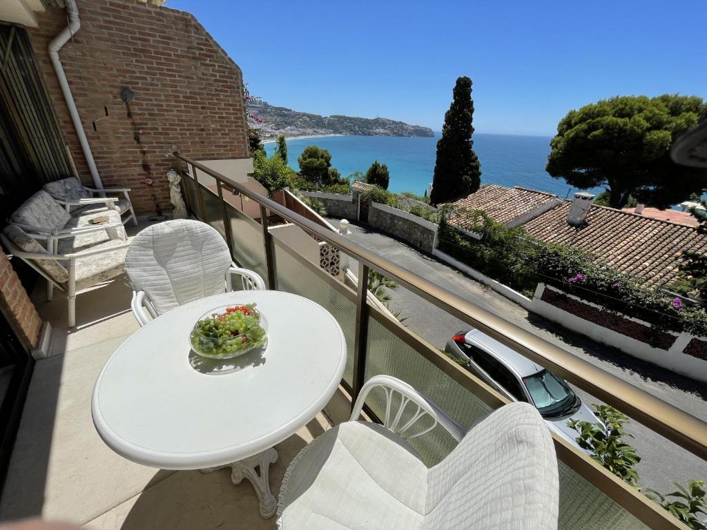 una mesa blanca y sillas en un balcón con vistas al océano en Montepino 48 en La Herradura
