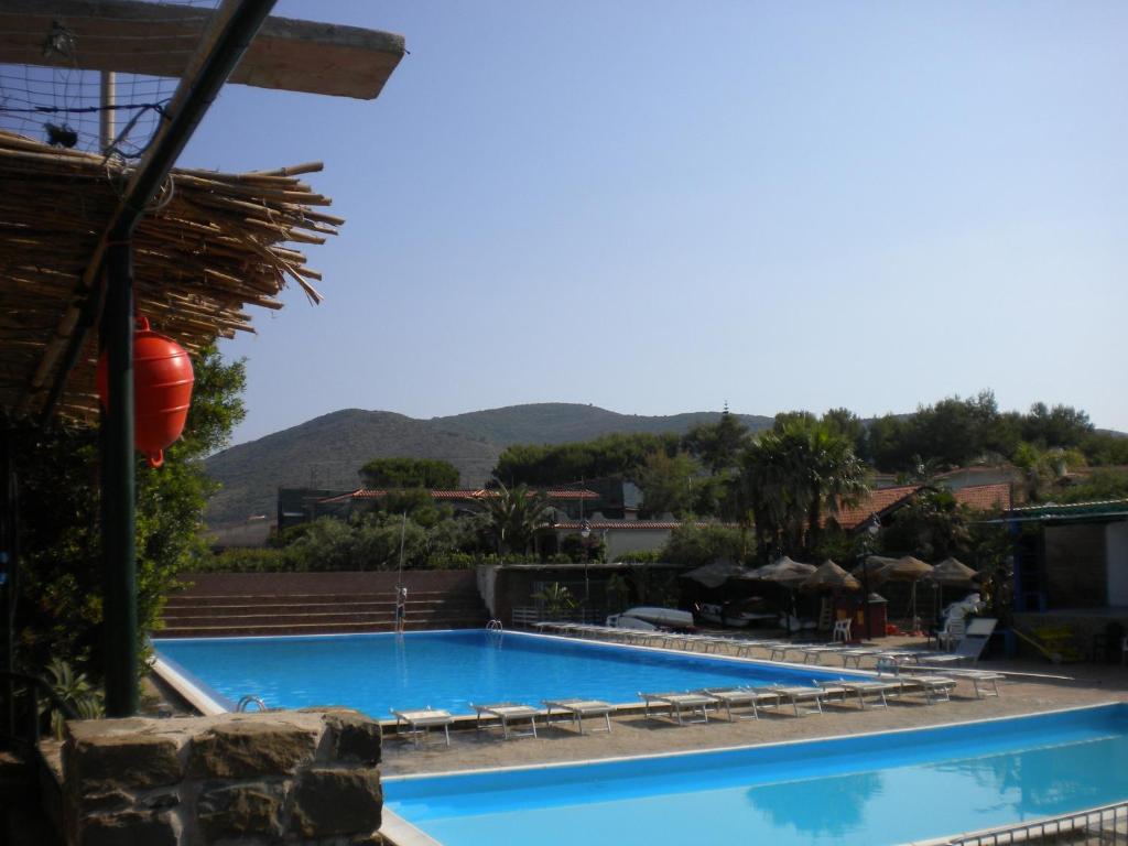 a large swimming pool with a mountain in the background at Villaggio Silvia in Castellabate