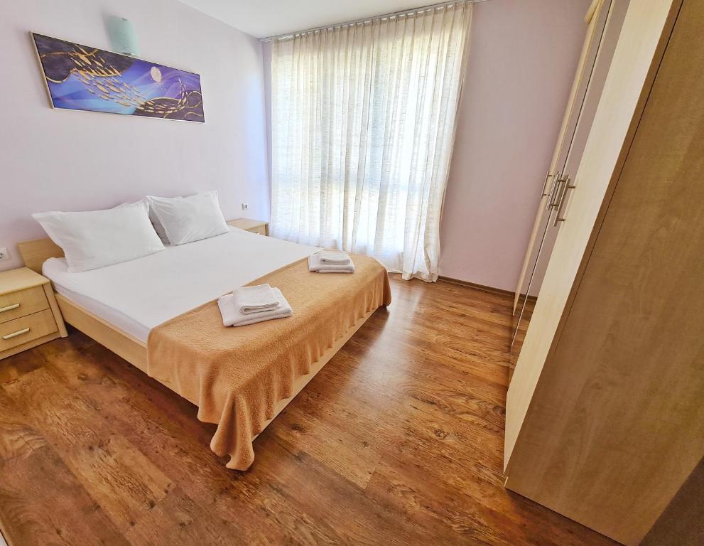 a bedroom with a bed with two towels on it at House Apartments Black sea Hotel in Obzor