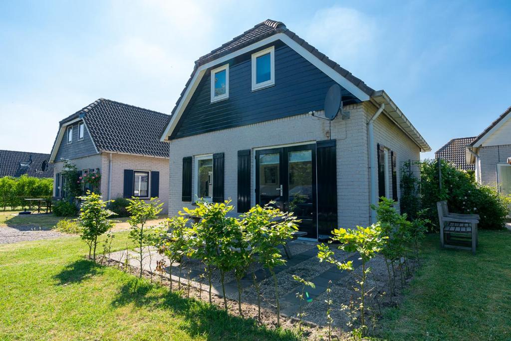 a house with a fence in the yard at Holiday home Zuiderdiep 6 Noordzeepark - Ouddorp, near the beach - not for companies in Ouddorp