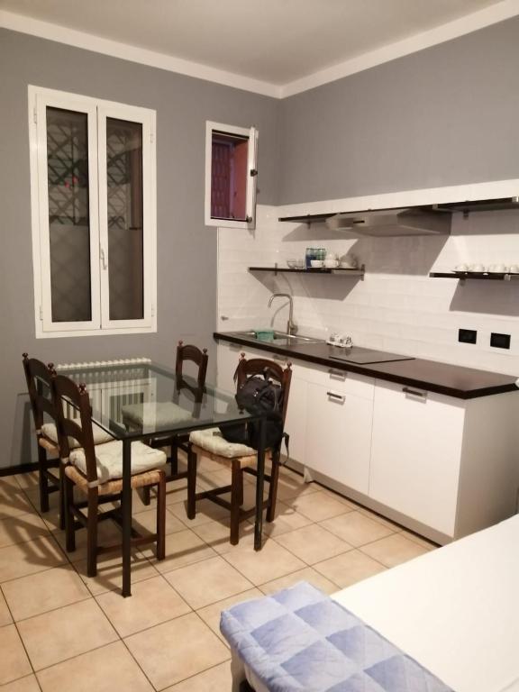 eine Küche mit einem Glastisch, Stühlen und einer Theke in der Unterkunft Casa Vincenzo in Bologna